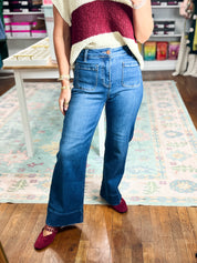 High-rise dark blue wide-leg jeans with front patch pockets, close front view