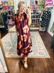 Sleeveless midi dress with burgundy floral pattern and sleeveless, flowy skirt