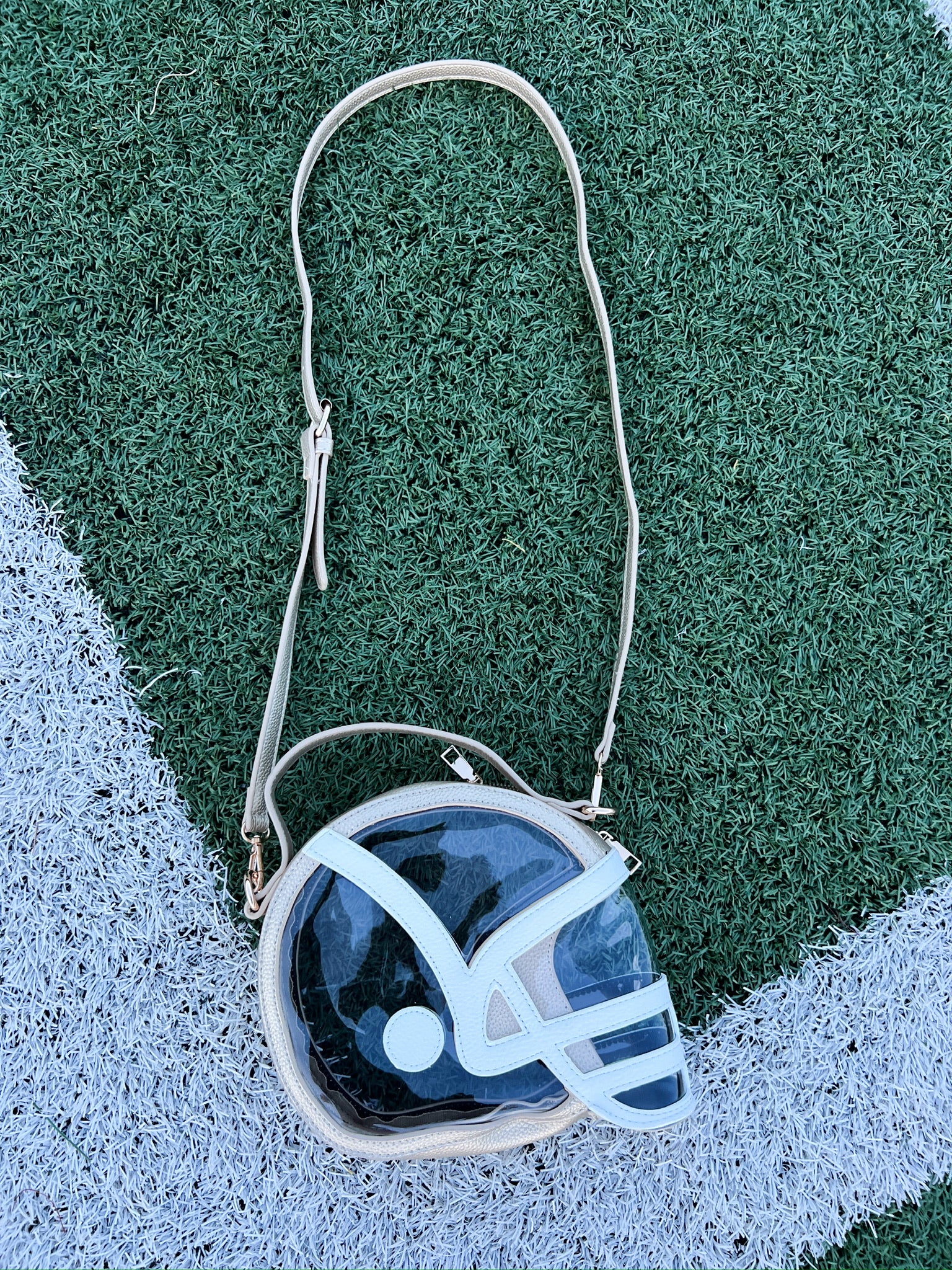 Helmet-shaped clear crossbody bag with white helmet graphic and long shoulder strap