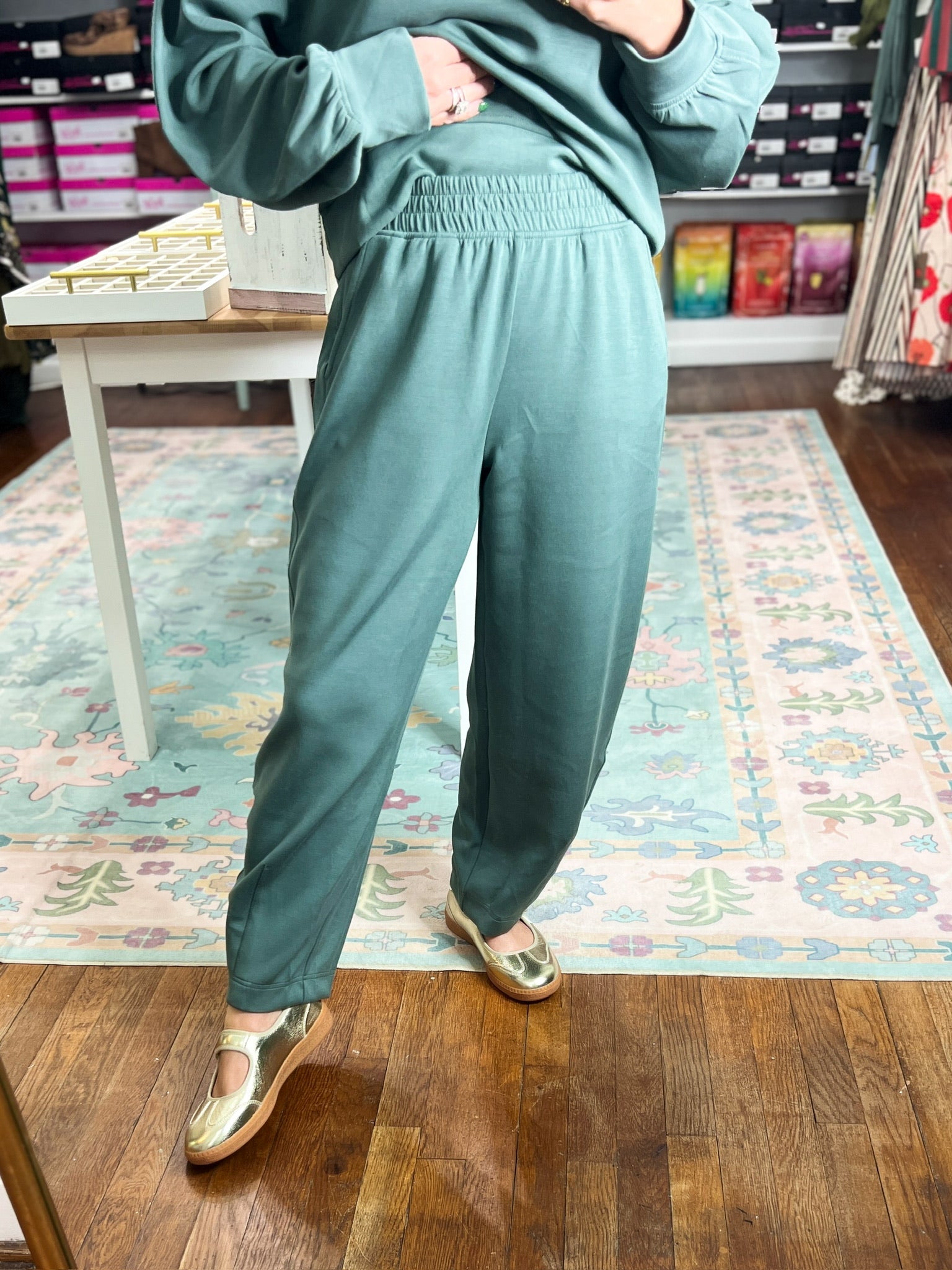 Sage green barrel pants with ruched elastic waist and side pockets, relaxed taper at hem