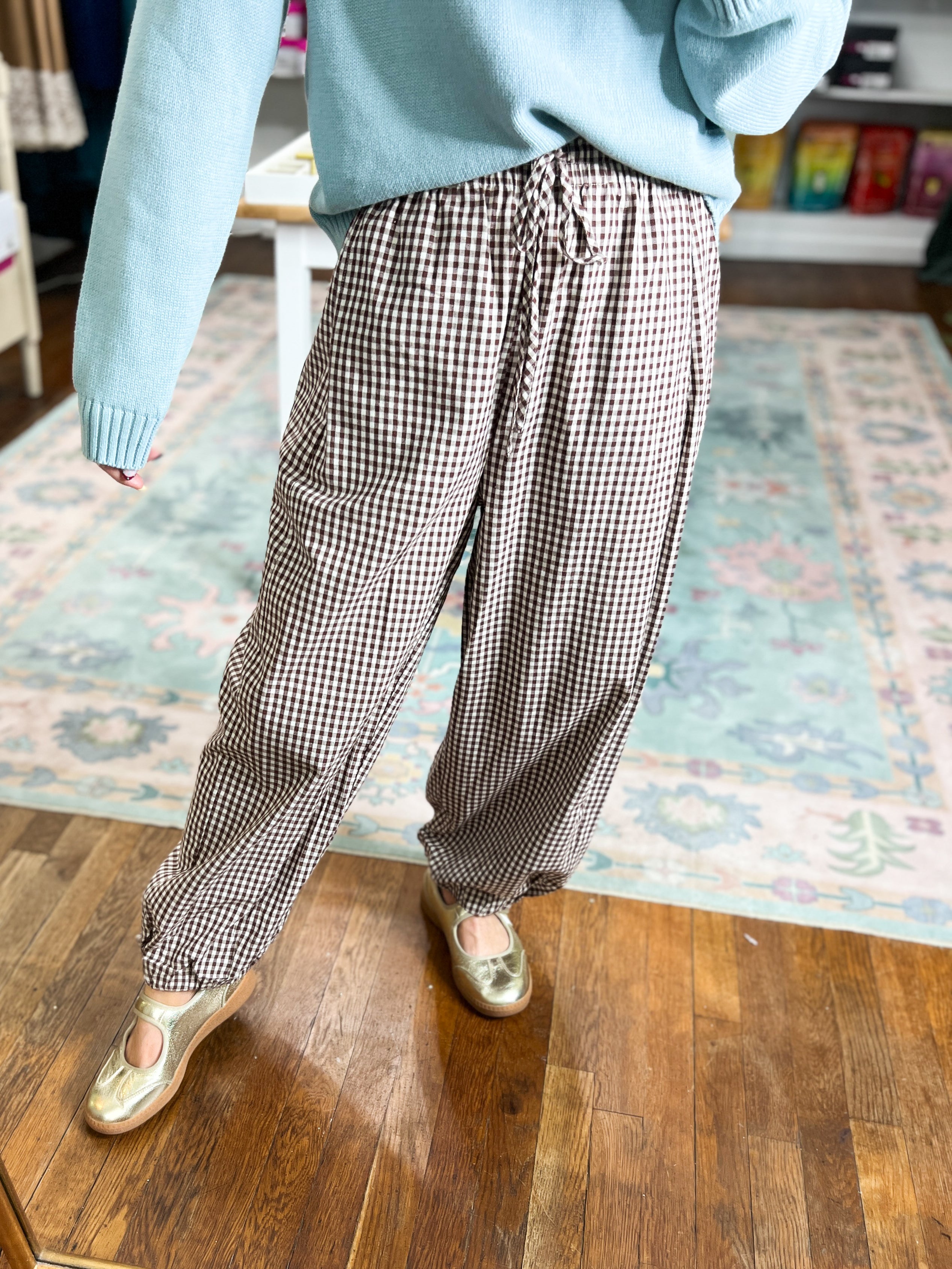 Brown gingham pants shown from the back, with a gathered drawstring waist.