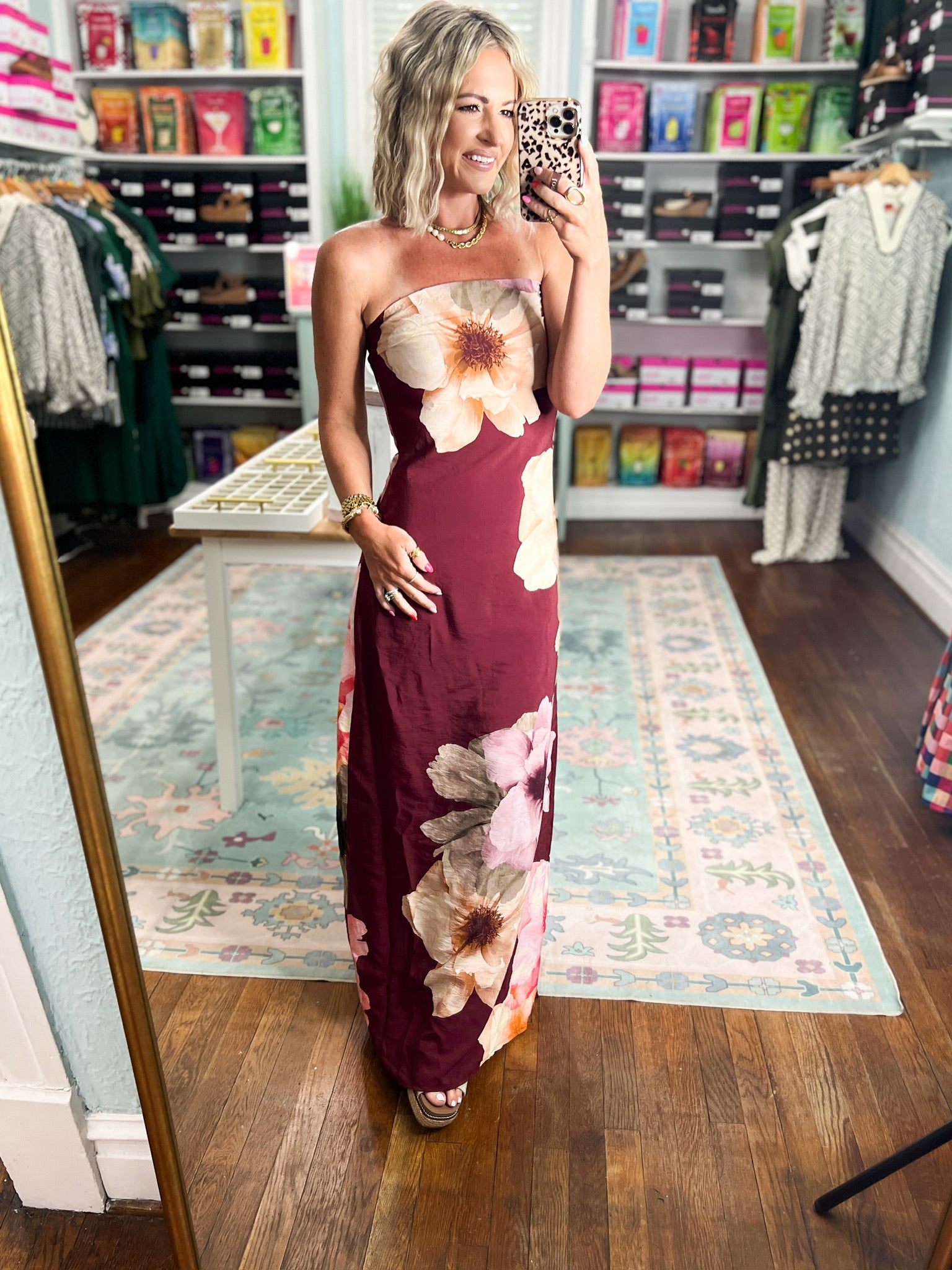Burgundy strapless maxi dress with large cream and pink flowers, fitted bodice and long skirt