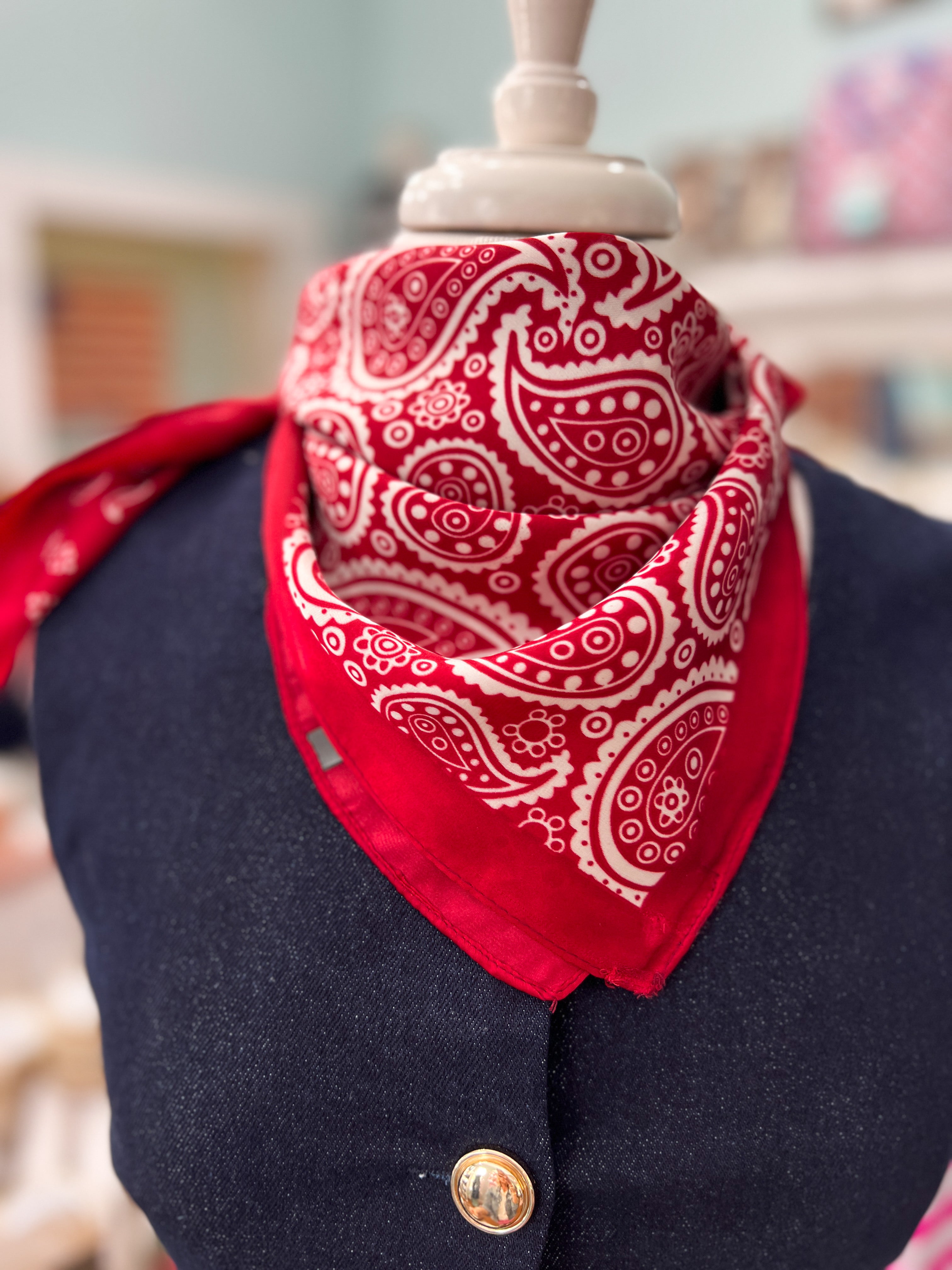 Red bandana scarf with white paisley swirl print, triangular drape