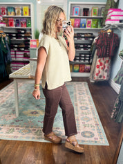 Brown straight pants with frayed ankle hem, side view