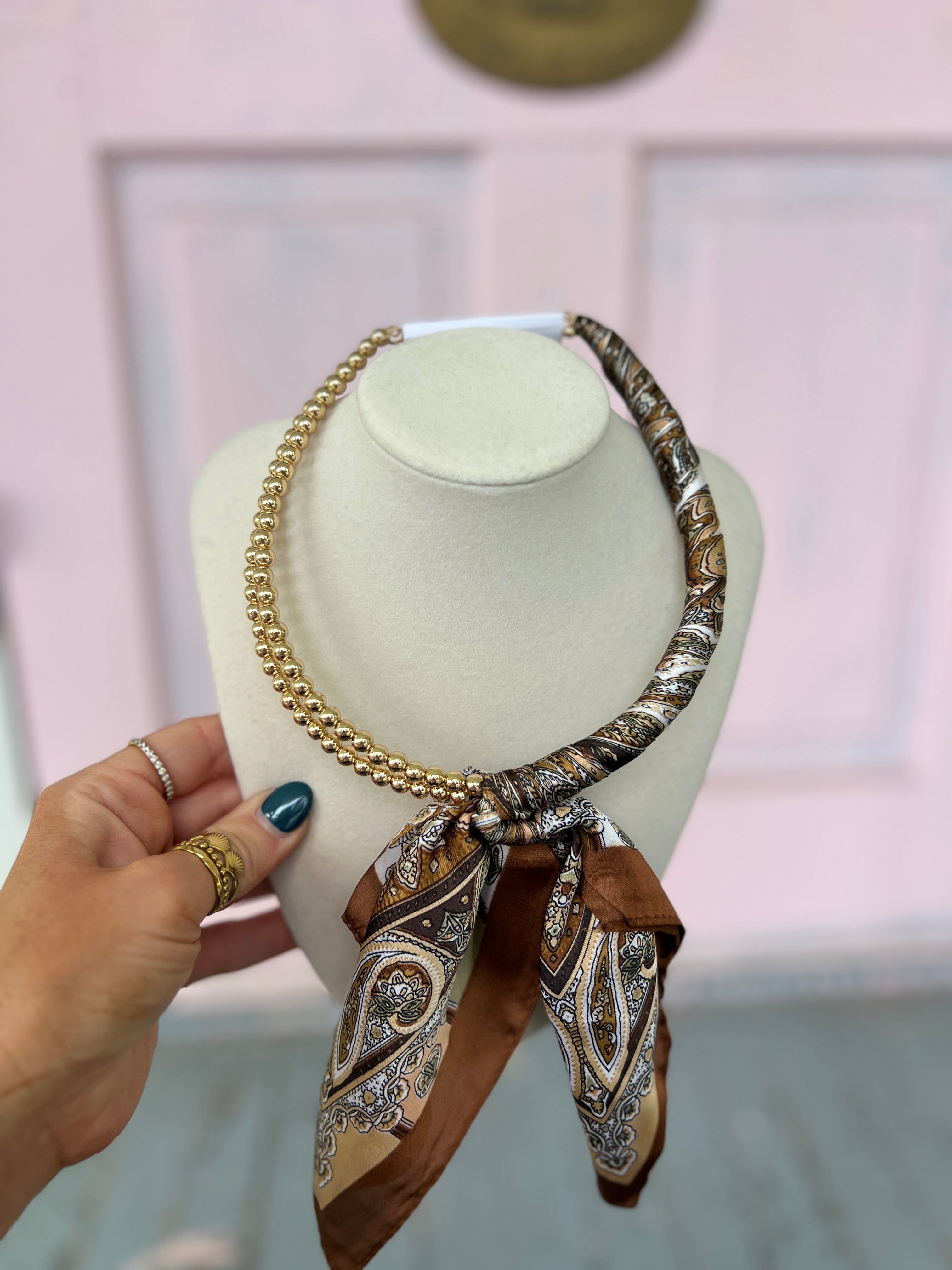 Brown scarf-wrapped collar necklace with gold chain and patterned scarf tail details