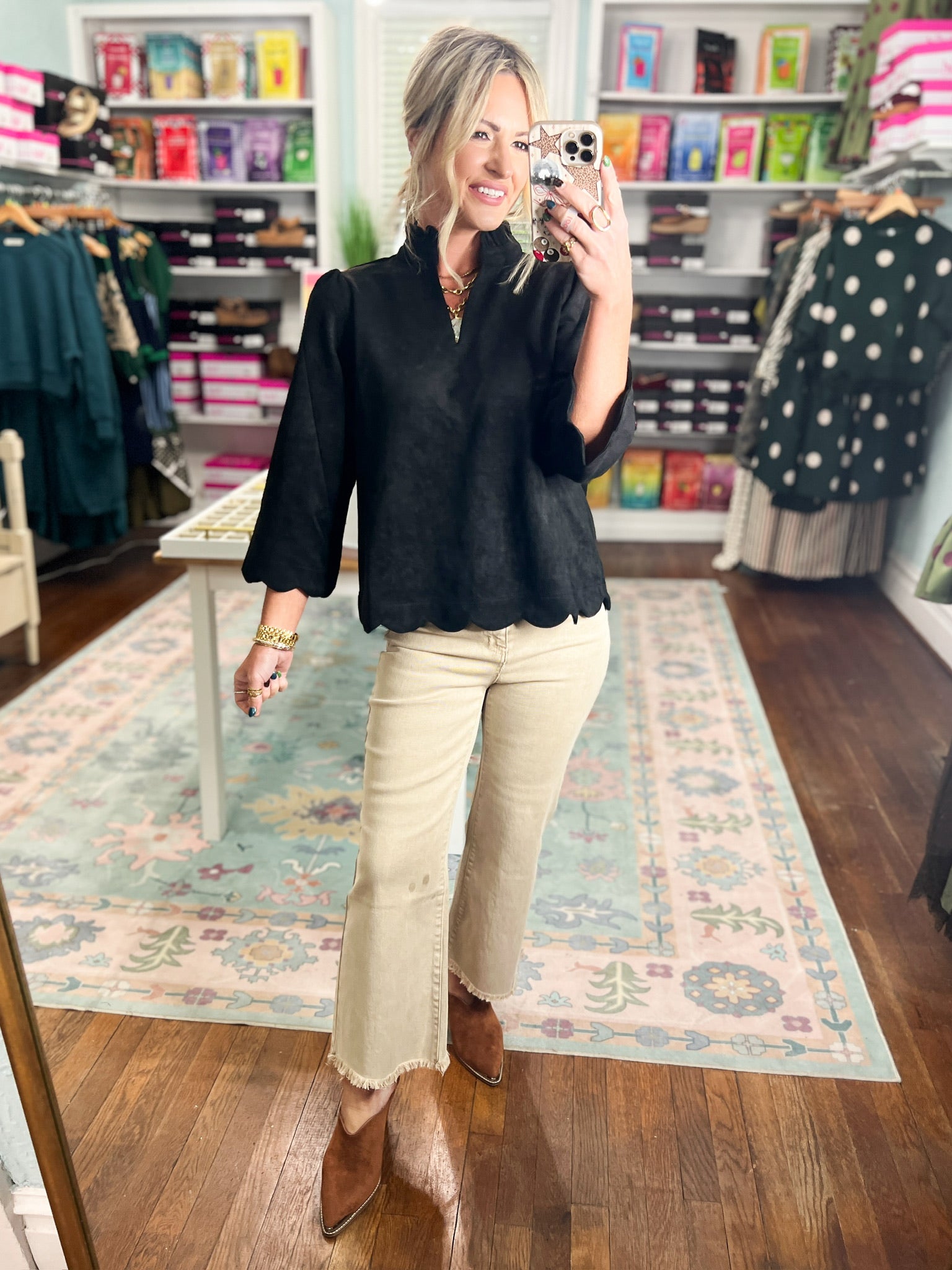 Black faux suede top with mock neck and scalloped hem, three-quarter puff sleeves