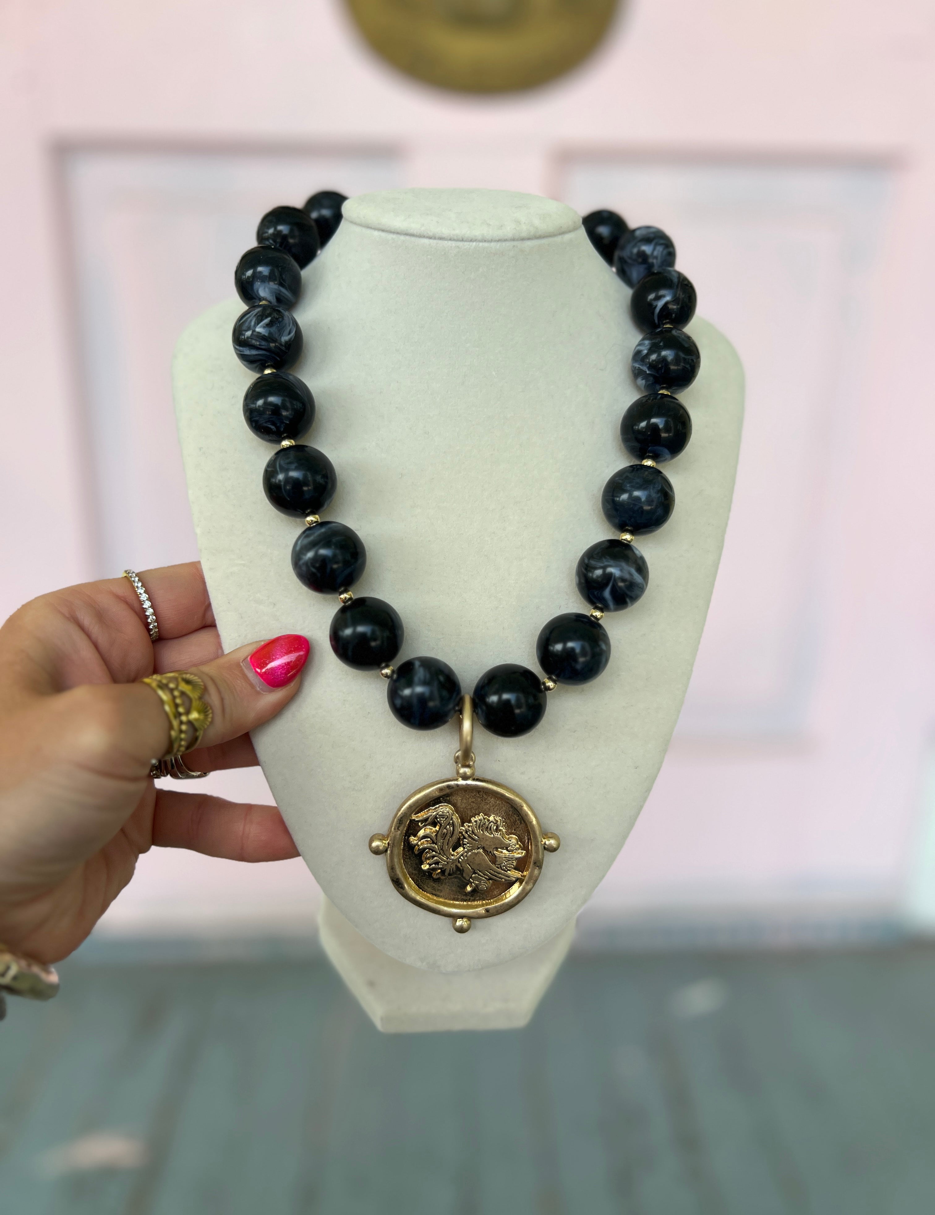 Black acrylic marble bead necklace with Gamecock medallion pendant on gold-tone chain