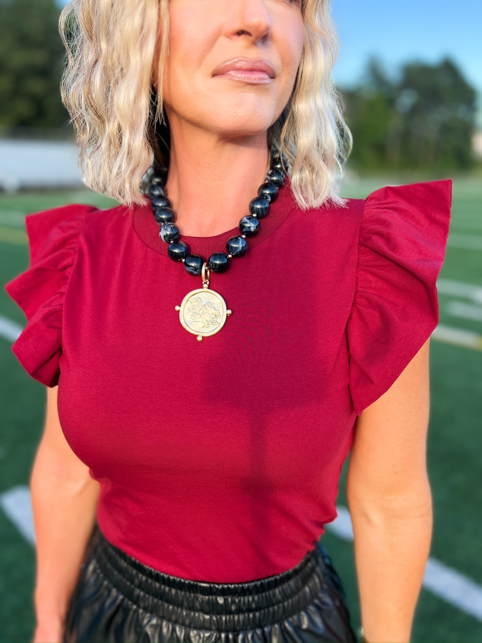 Crimson flutter sleeve top with textured knit and ruffled shoulders