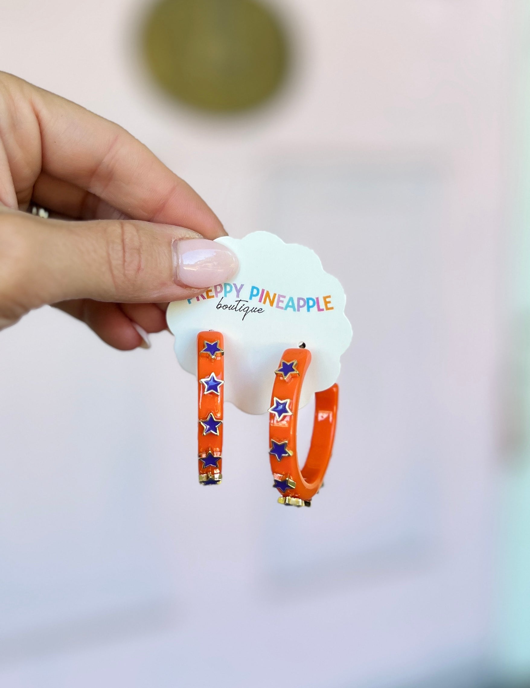 Star-trim acetate hoop earrings with orange hoops and blue star accents, trimmed edge