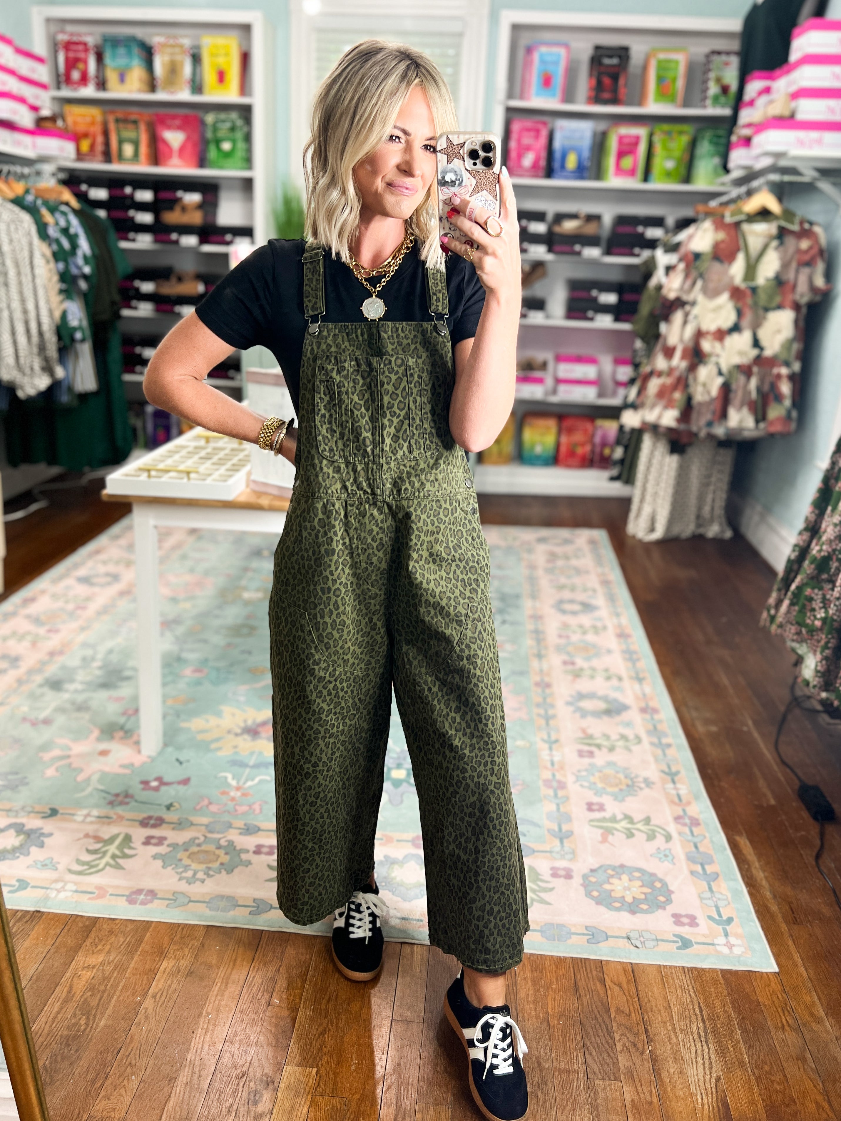 Olive patterned twill overalls with bib front and wide legs, worn with black sneakers