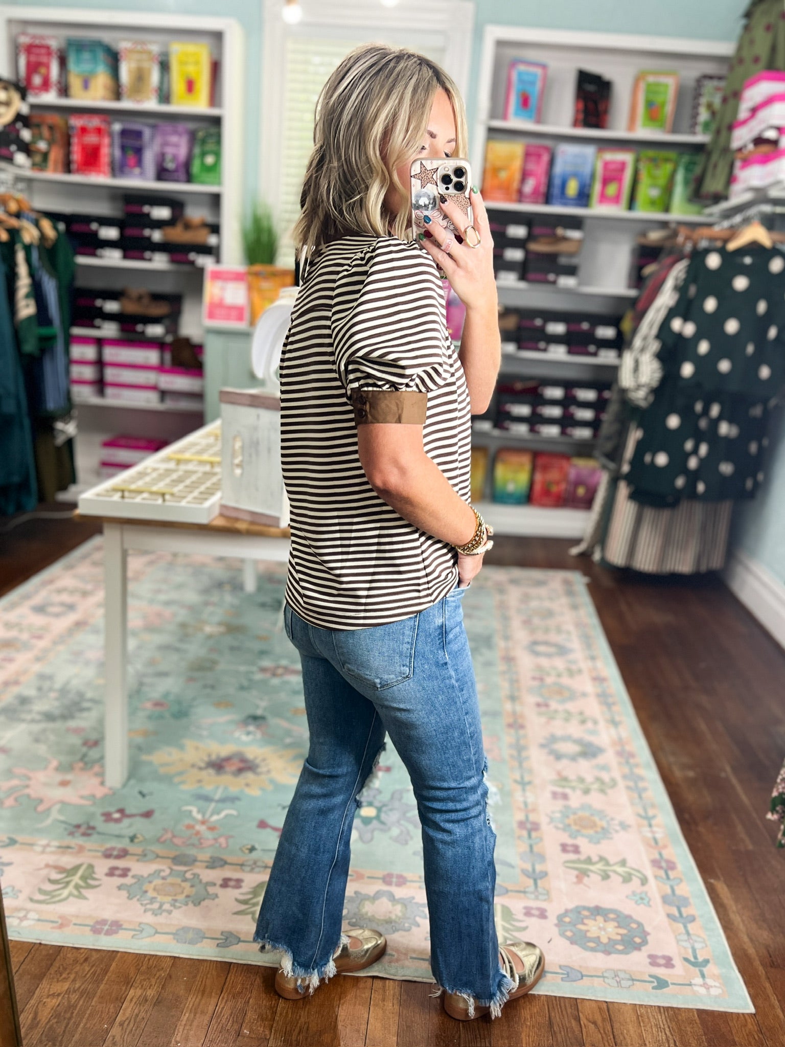Striped short sleeve V-neck top with brown neckline trim, worn with jeans