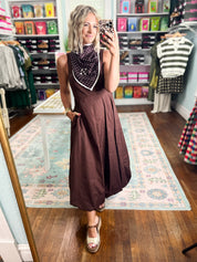 Brown sleeveless midi dress with draped polka-dot panel and full gathered skirt