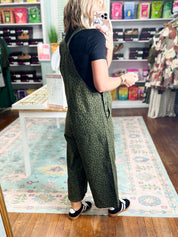 Olive patterned twill overalls with bib front, wide legs, and adjustable straps