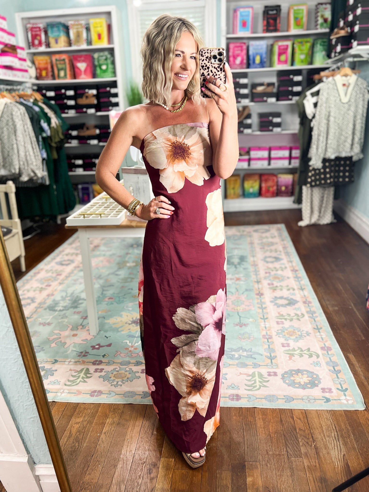Burgundy strapless maxi dress with bold cream and pink floral clusters, fitted floor-length fit