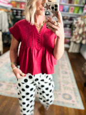 Crimson poplin top with V-neck, button-front, and textured pintuck yoke
