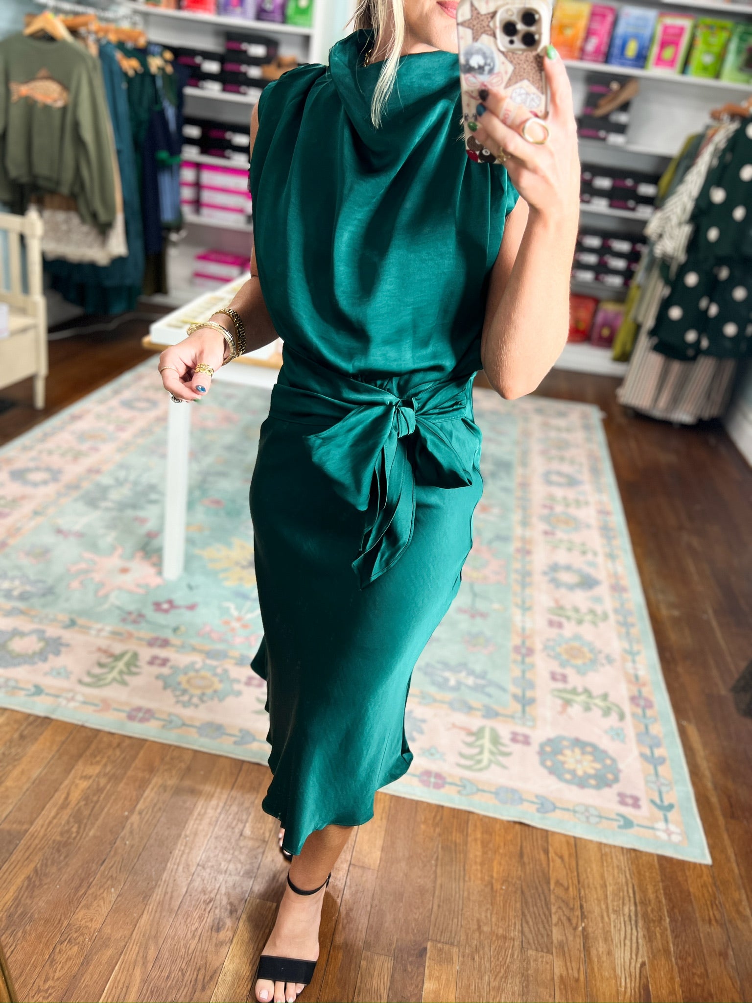 Teal sleeveless midi dress with twisted waist tie and fitted skirt.