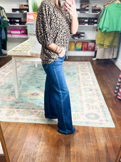 Women's high-rise wide-leg jeans with adjustable waist, blue denim; side profile.