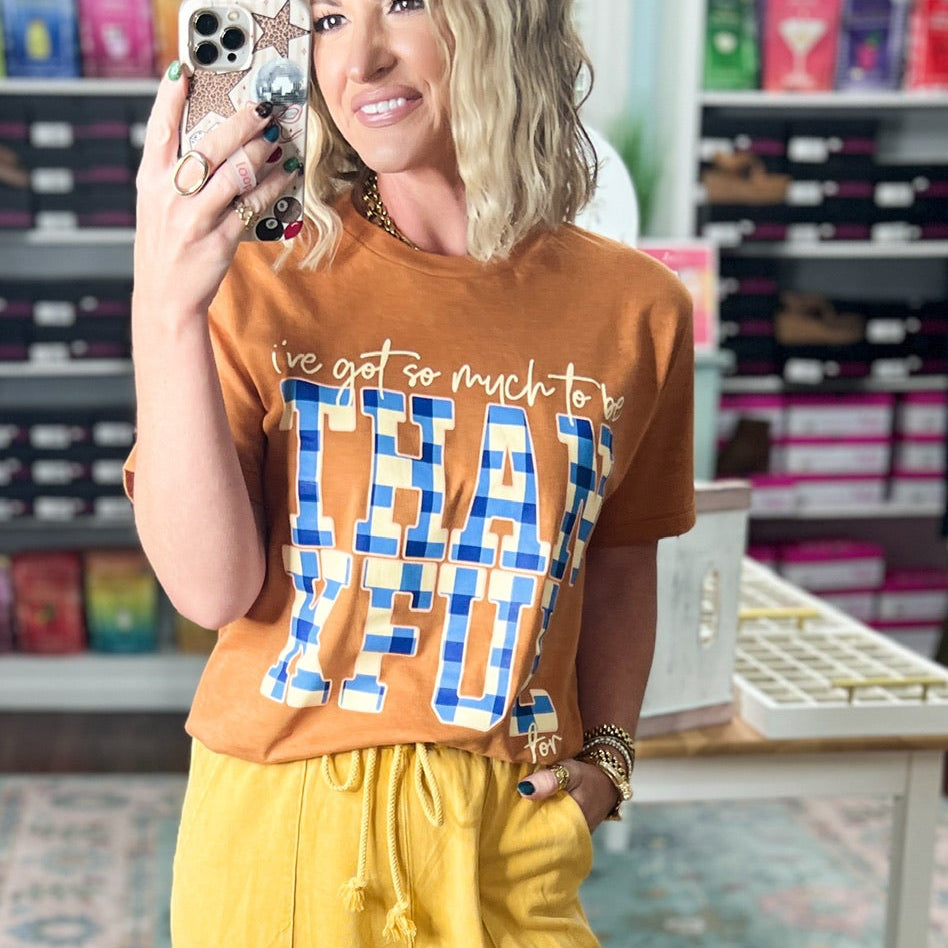 Orange short-sleeve graphic T-shirt with crew neck and blue printed lettering