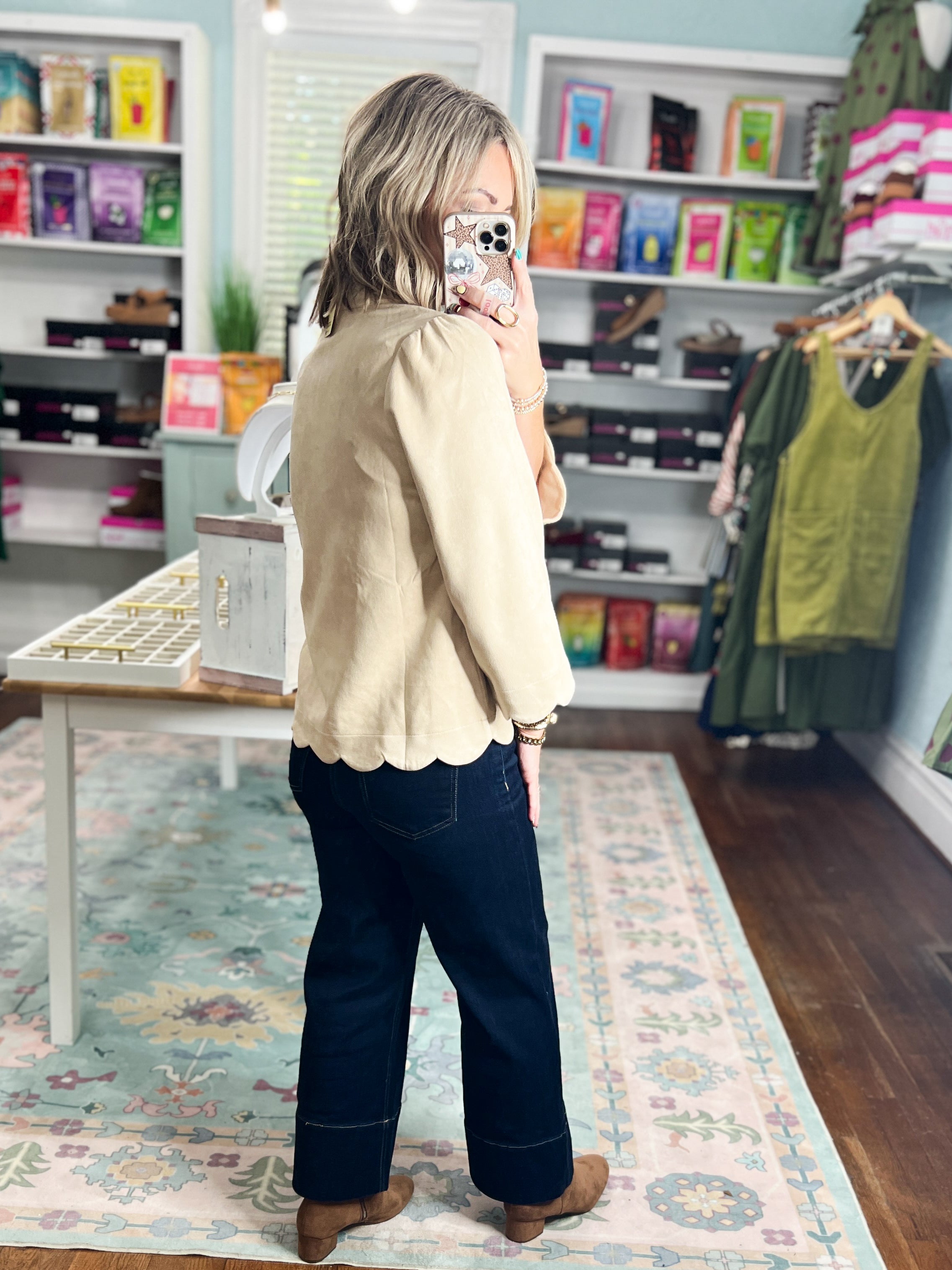 Champagne faux suede blouse viewed from back-left, long sleeves and scalloped hem.