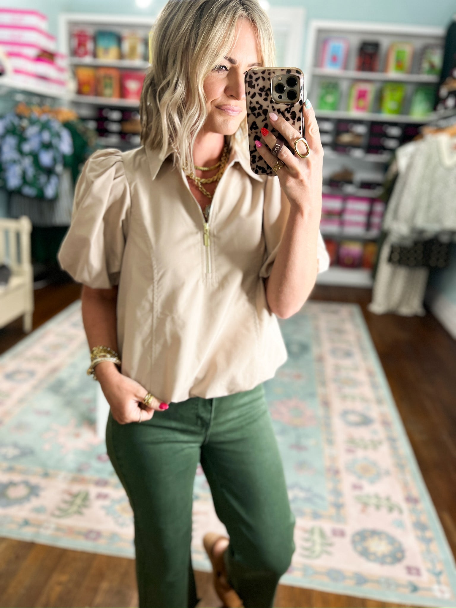 Light taupe puff-sleeve blouse with stand collar and half-zip front, close-up