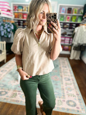 Light taupe puff-sleeve blouse with stand collar and half-zip front, close-up