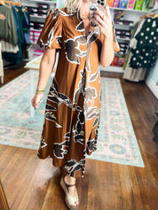 Rust-brown dress with puff sleeves and abstract black-and-white floral print