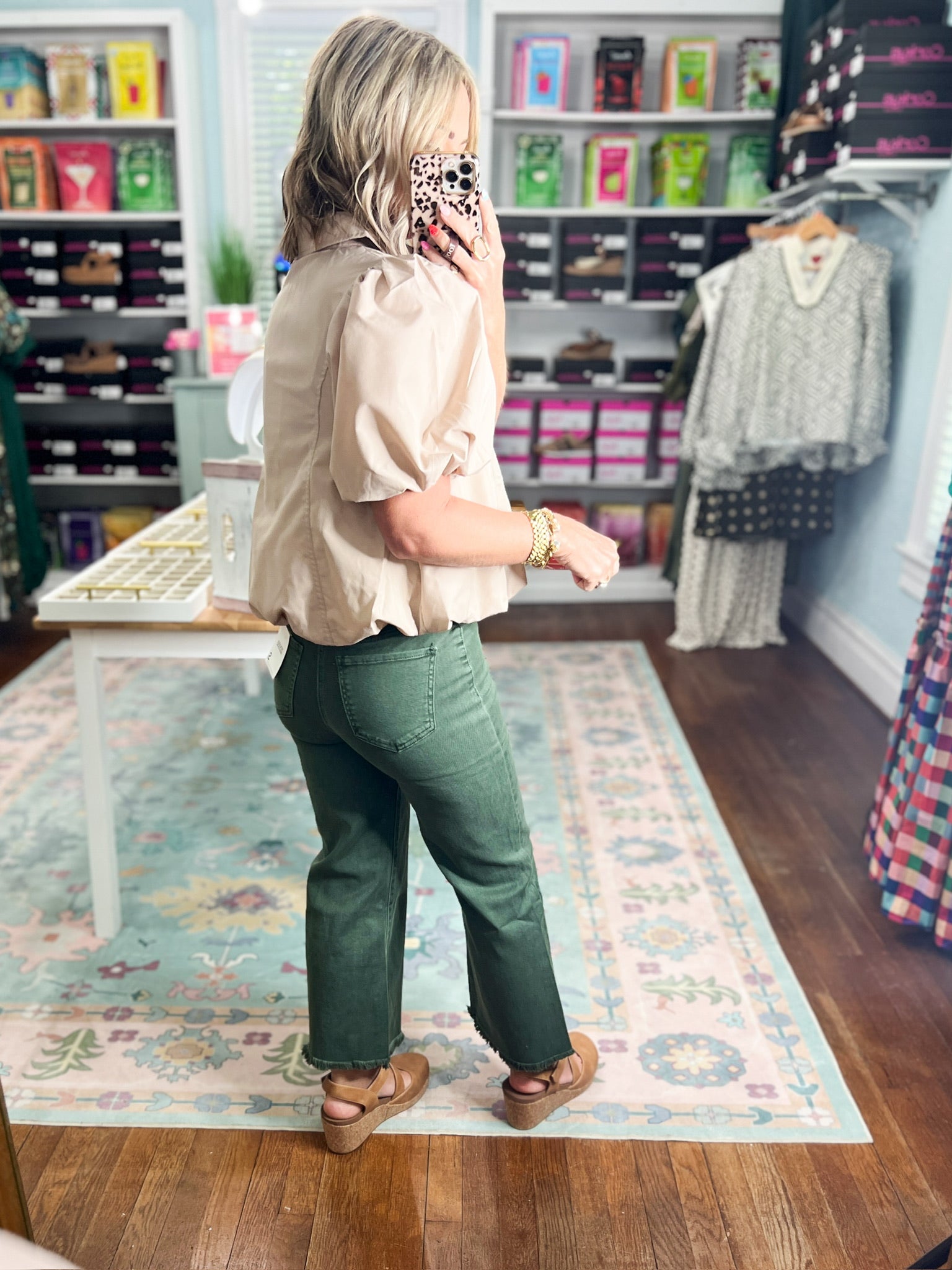 Light taupe puff-sleeve blouse with stand collar and front zip, angled back view