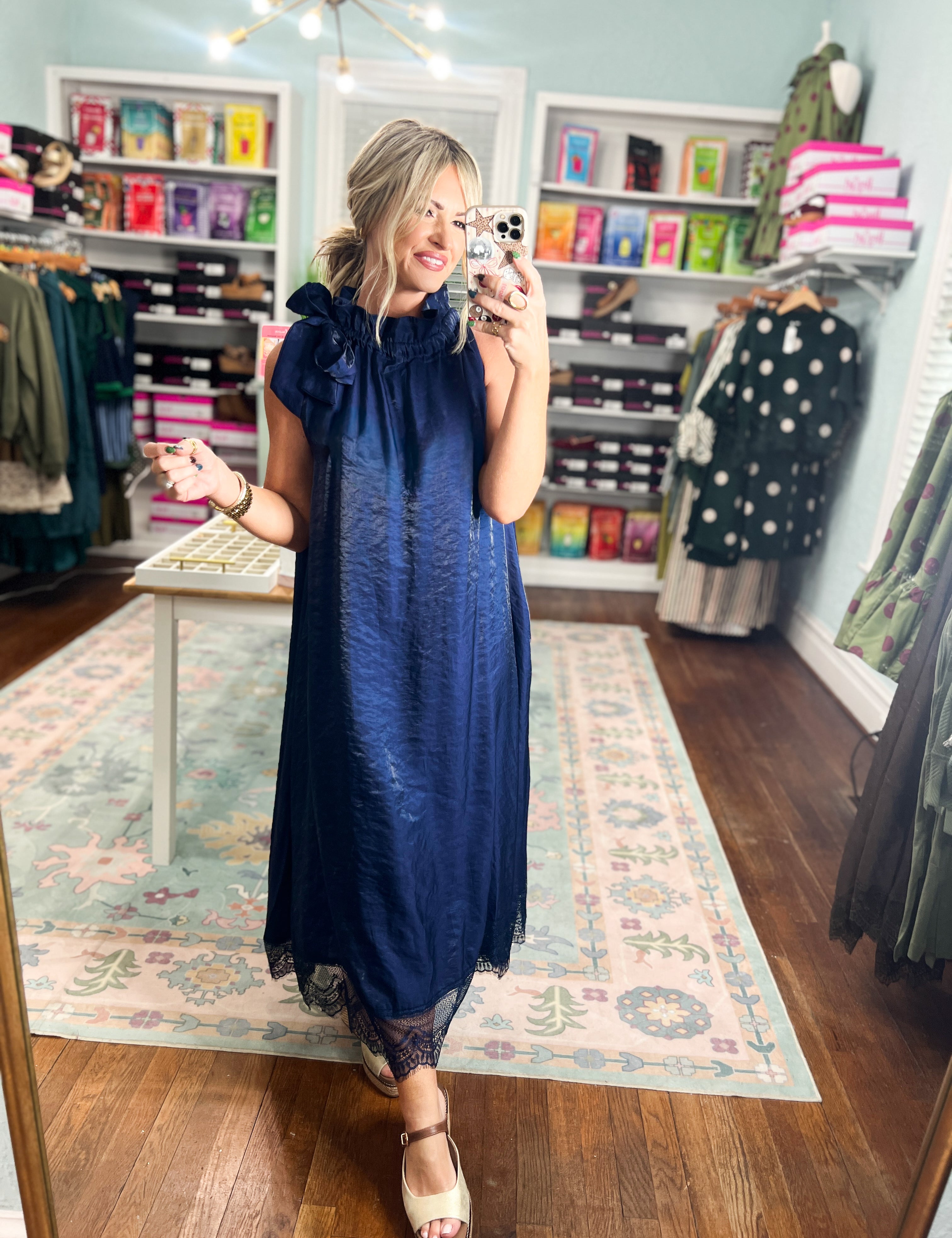 Navy sleeveless midi dress with lace hem and ruffled shoulders, standing view