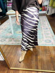 Close-up of brown zebra-print midi pencil skirt with white wavy stripe pattern