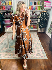 Rust-brown puff sleeve maxi dress with abstract black-and-white floral print