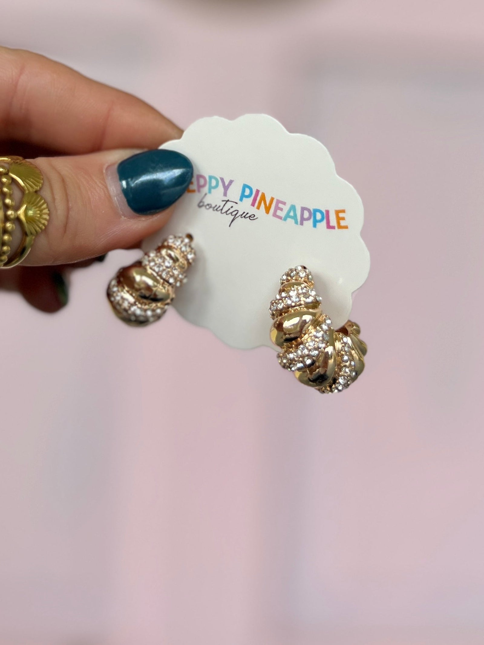 Gold textured hoop earrings with clear stone embellishment