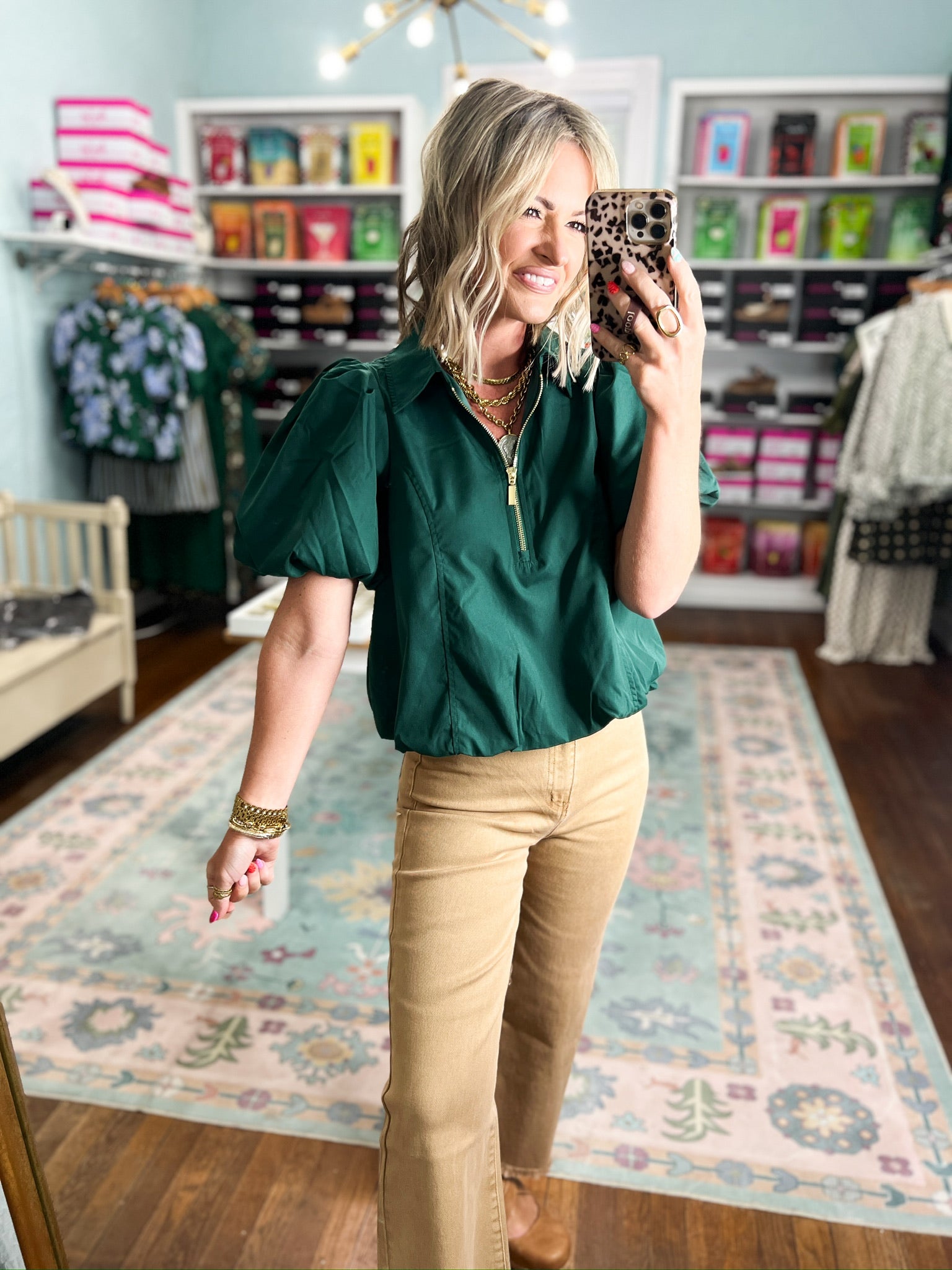 Hunter green puff-sleeve top with half-zip and gold zipper detail