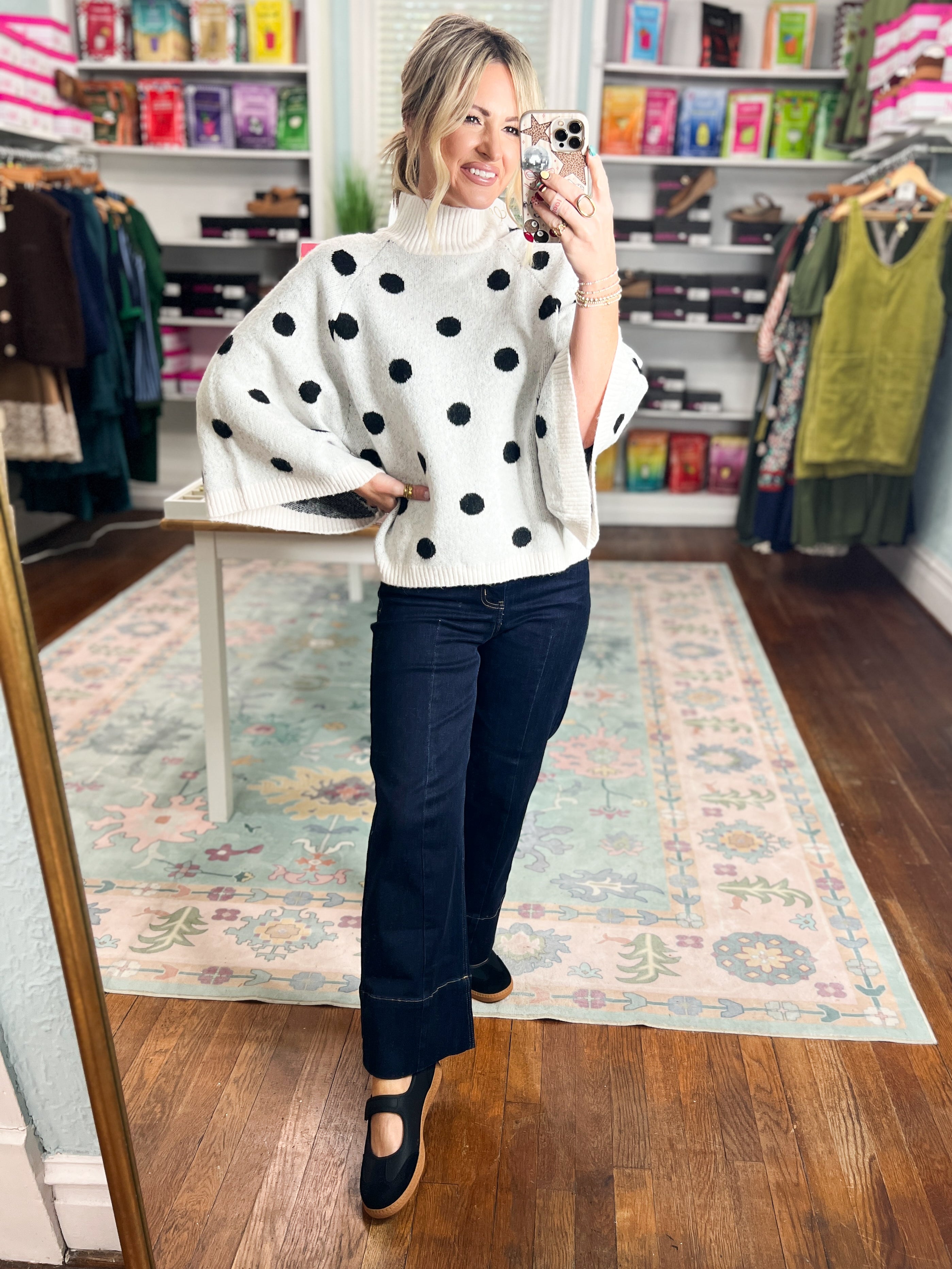 Cream knit sweater with scattered black polka dots and ribbed collar, loose hem