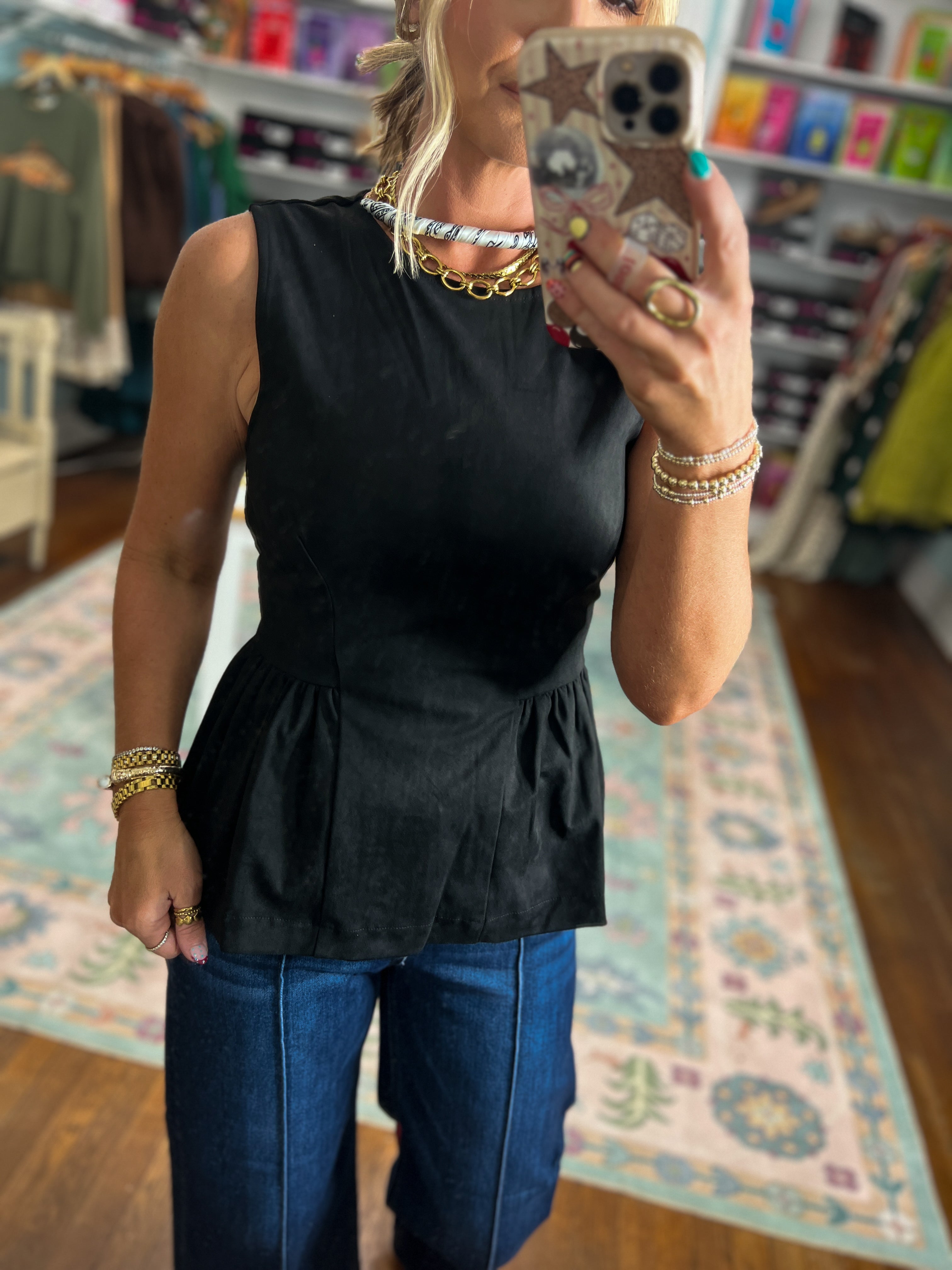 Black sleeveless peplum top with cinched waist and round neckline