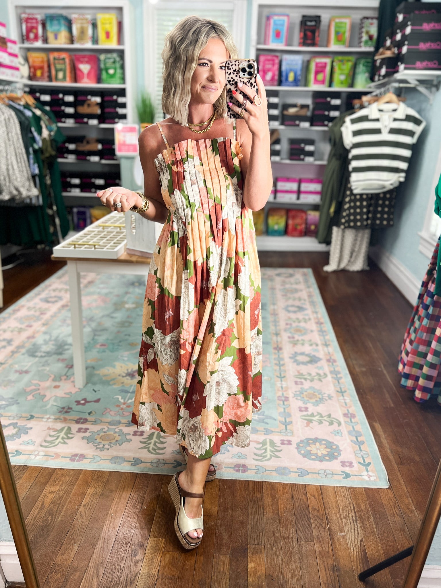 Floral pleated midi dress standing pose, sleeveless square neckline and wide straps