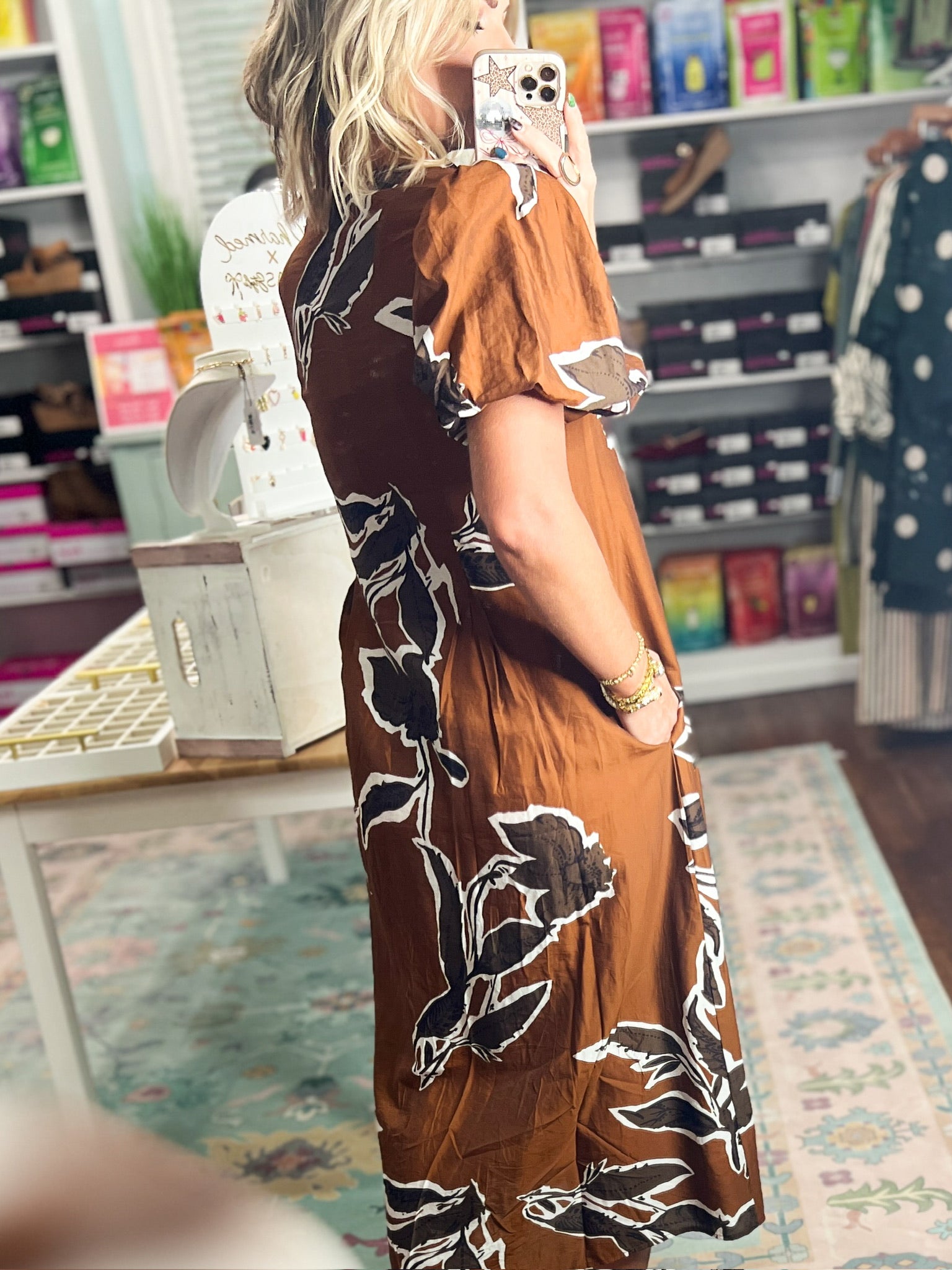 Rust-brown puff sleeve dress with abstract black and white floral print, side view