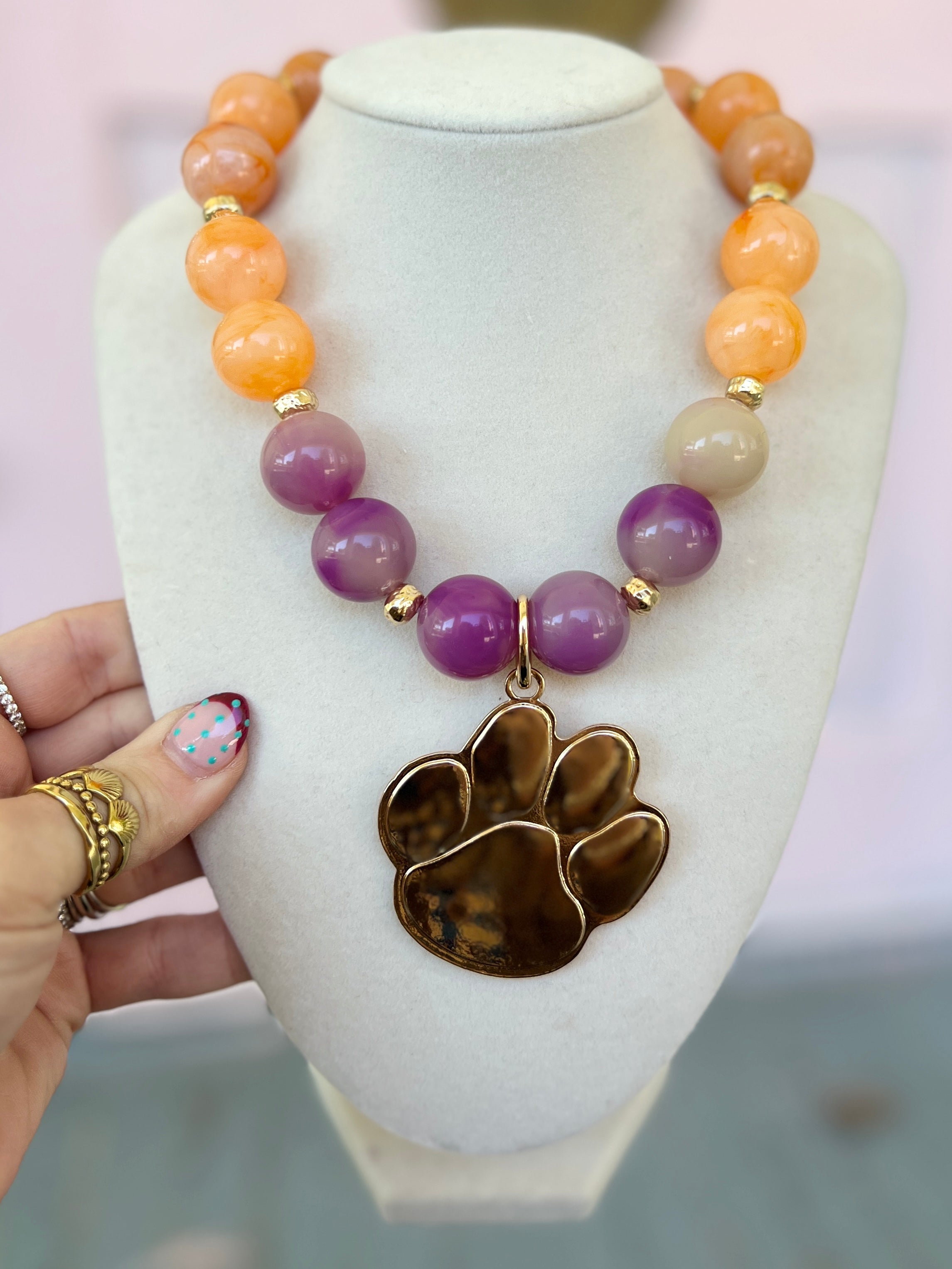 Acrylic bead necklace with orange and purple marble beads and gold-tone paw pendant