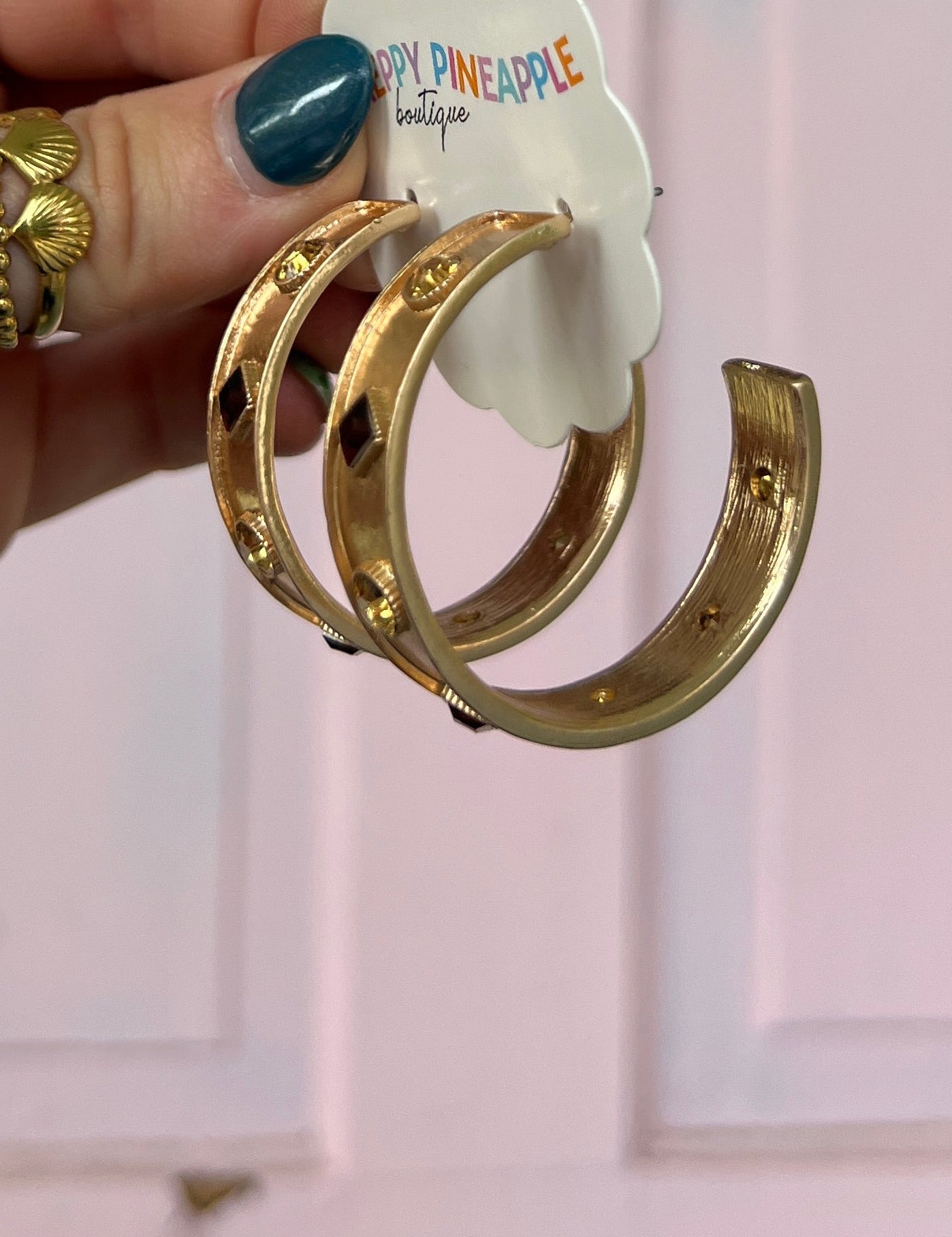 Gold-tone hoop earrings with red square center stone and round stud stations