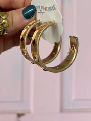 Gold-tone hoop earrings with red square center stone and round stud stations