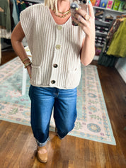 Beige knit sweater vest with textured knit and dark button-front, sleeveless