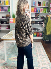 Back view of taupe leopard print pleated blouse top with V-neckline