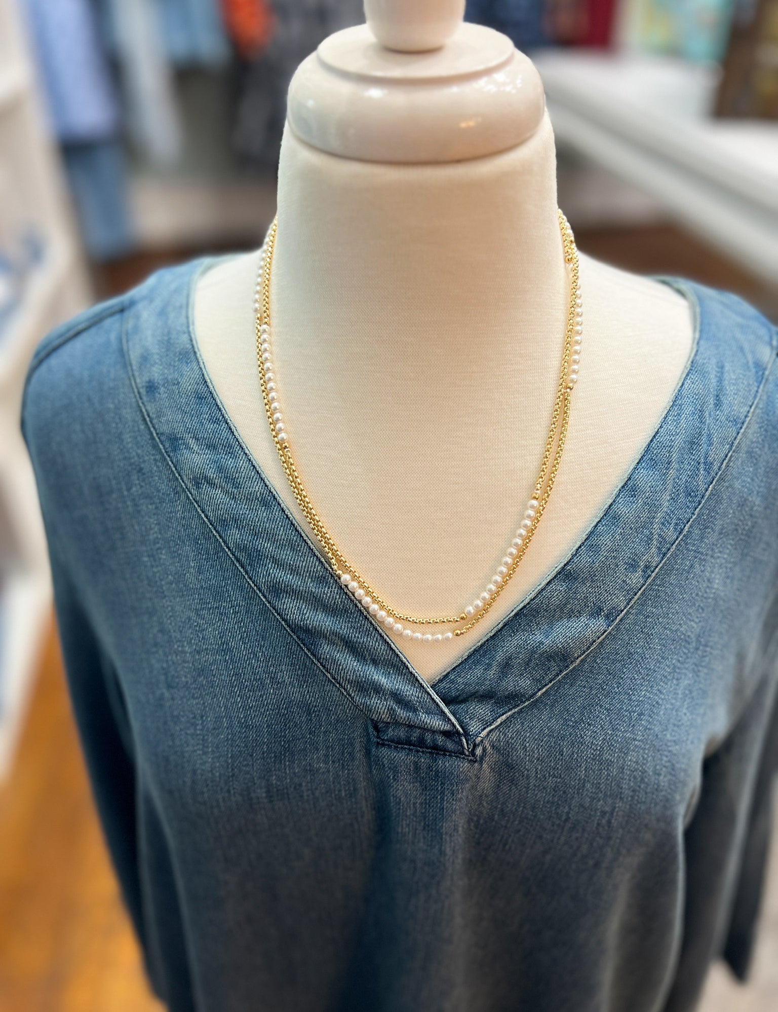 Layered gold-tone necklace with pearl bead strands, longer length on mannequin