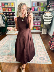 Brown sleeveless midi dress with fitted bodice and draped polka-dot waist panel