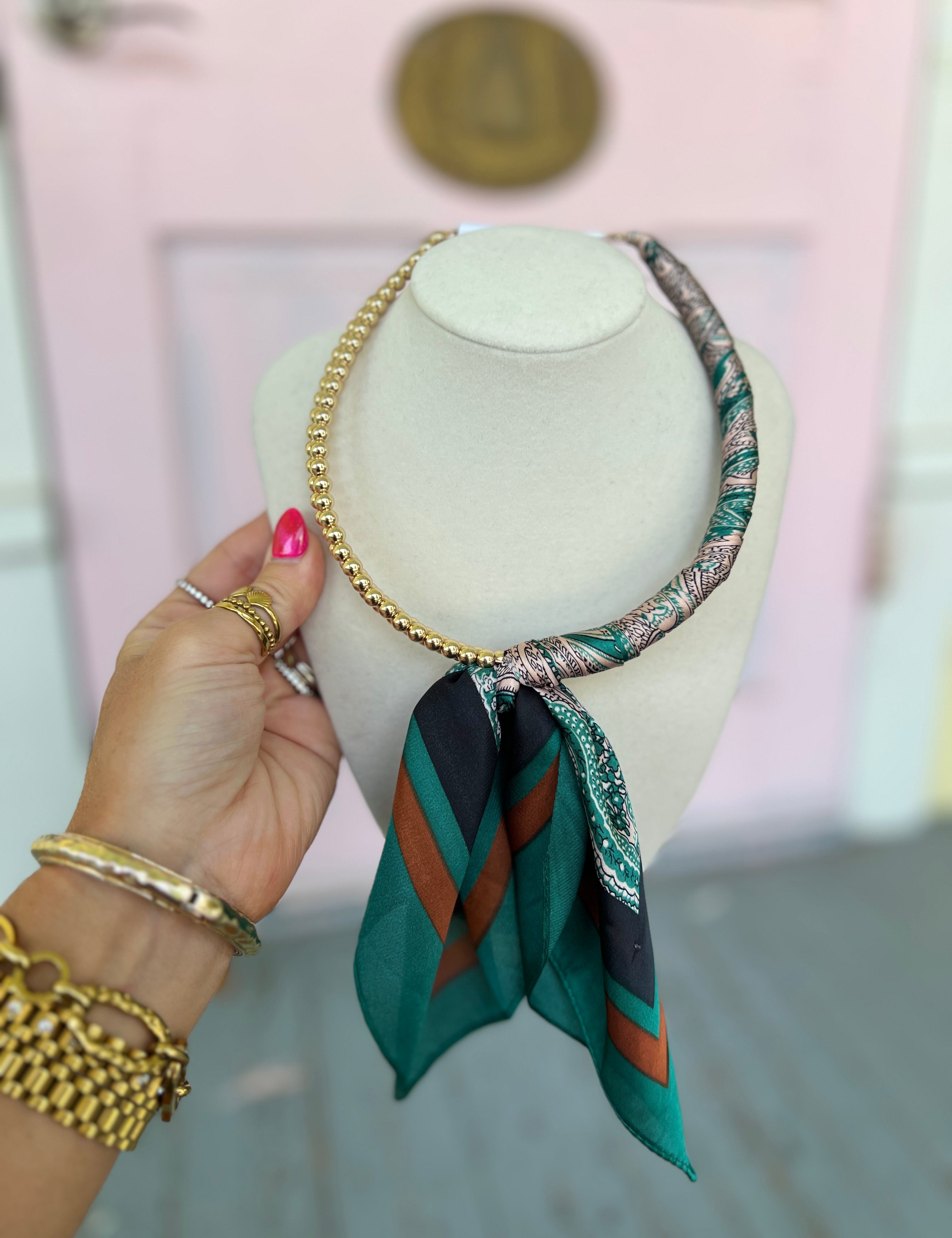 Teal scarf ball necklace with gold chain and patterned teal scarf drape