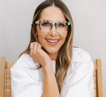 Orchid blossom and navy eyeglass frames with clear lenses, worn front view