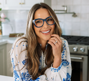 Navy eyeglasses with blue patterned temples on a smiling woman