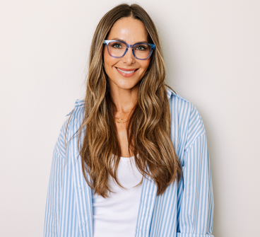 Woman wearing light blue eyeglasses with clear lenses and a blue striped shirt