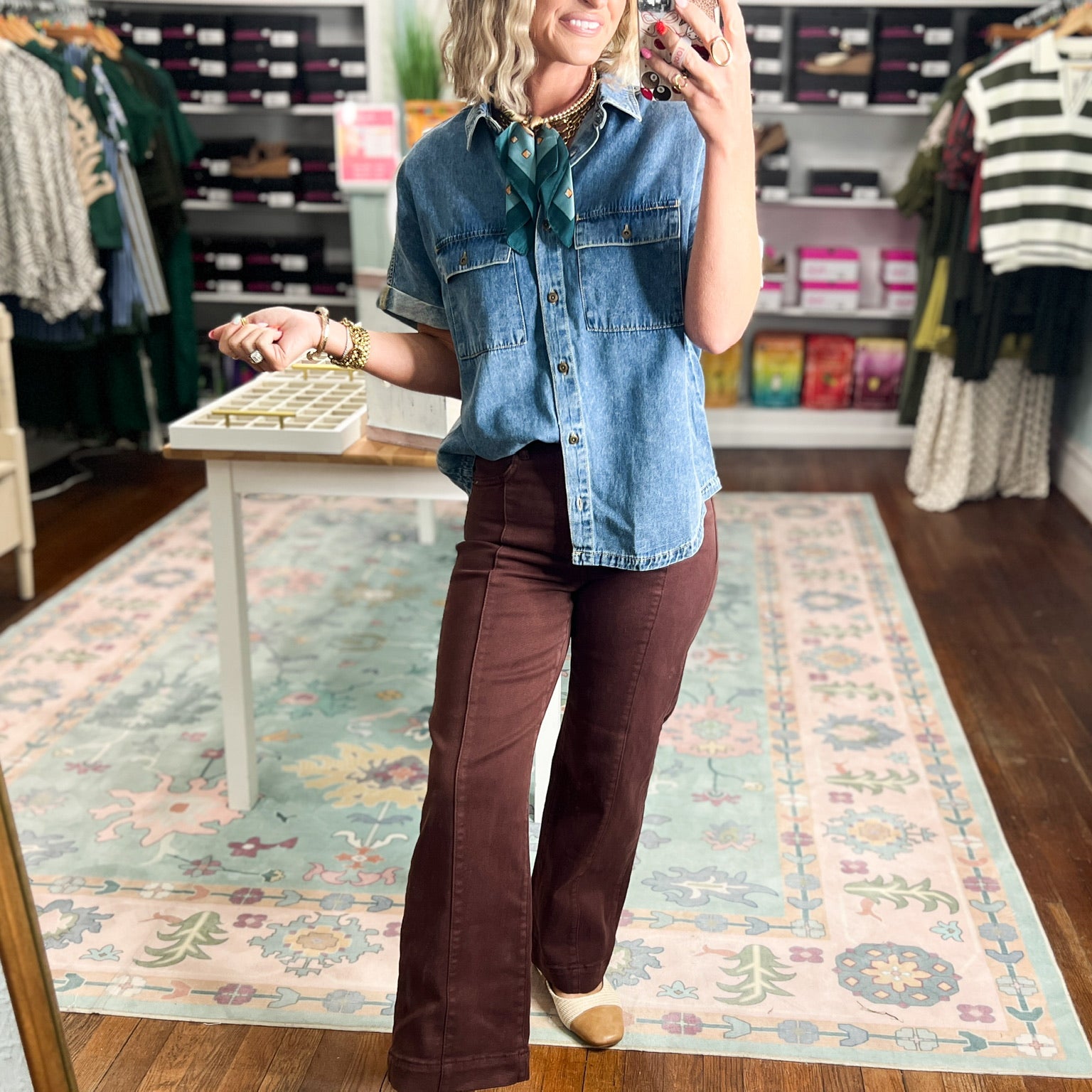 Medium-wash long denim shirt with collared neckline, chest flap pockets, and button closure