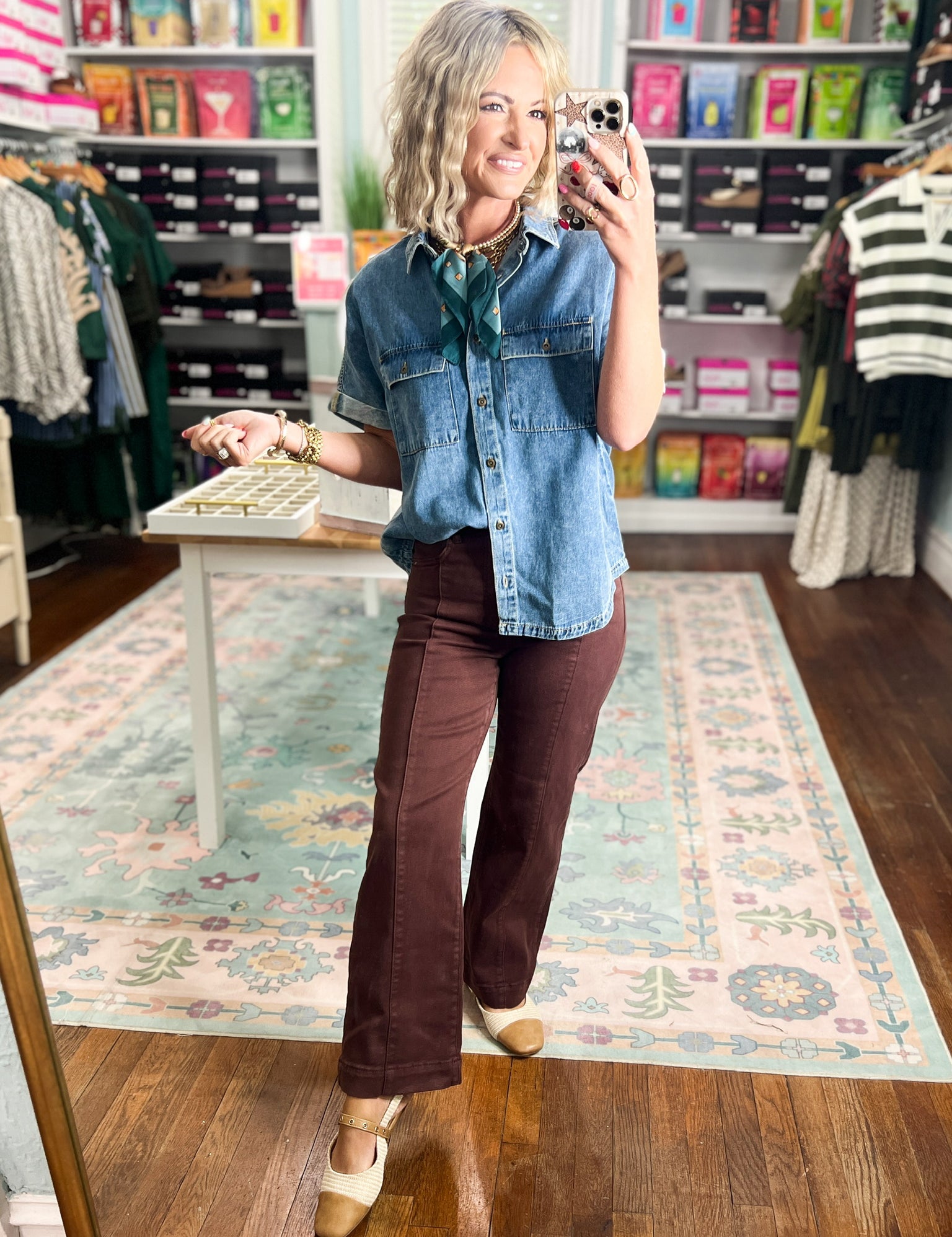 Medium-wash long denim shirt with collared neckline, chest flap pockets, and button closure