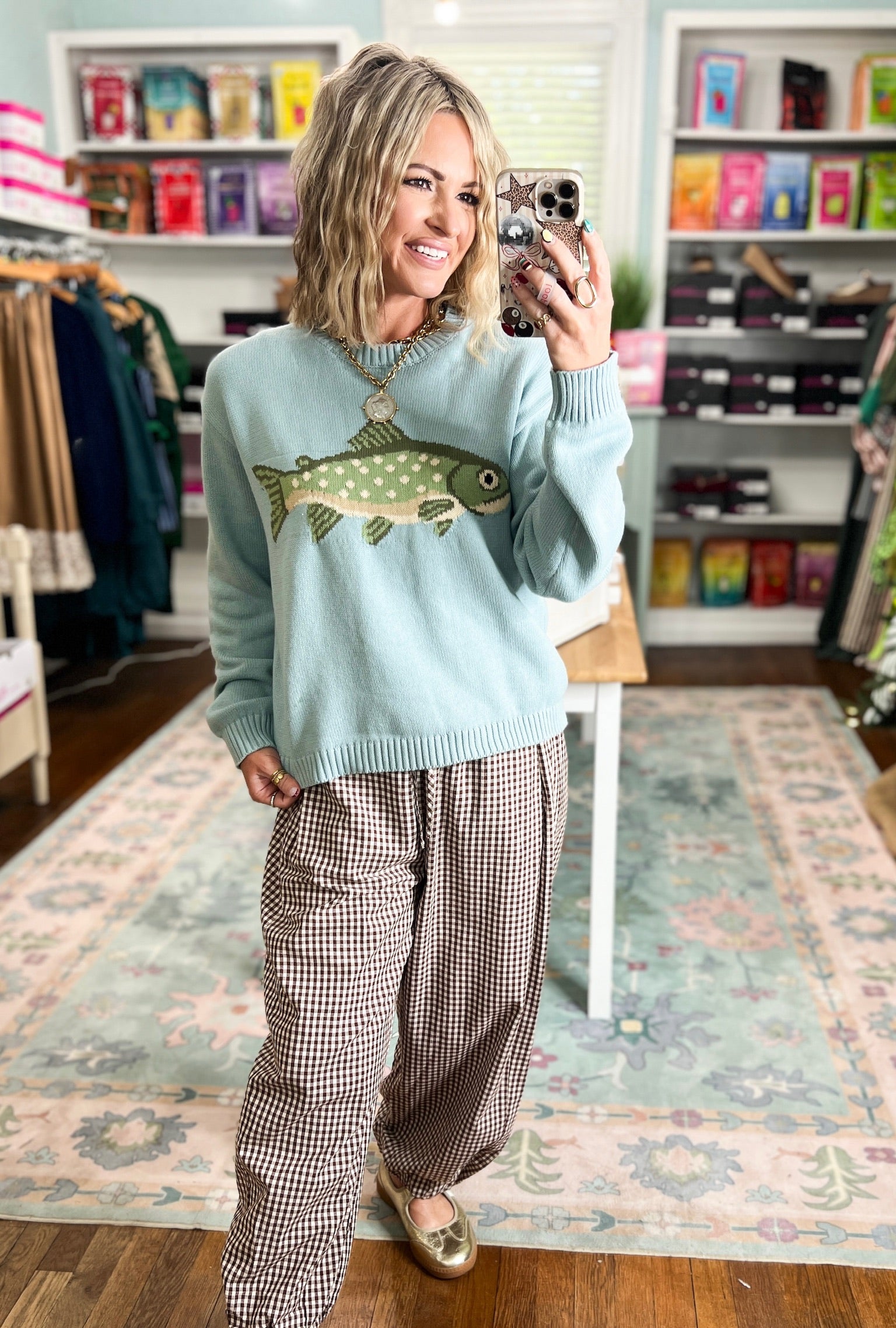 Sage sweater featuring a green fish graphic across the front